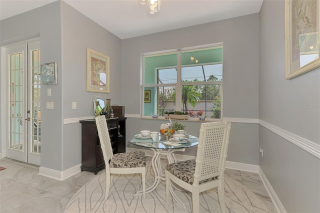 dining space with marble finish floor and baseboards