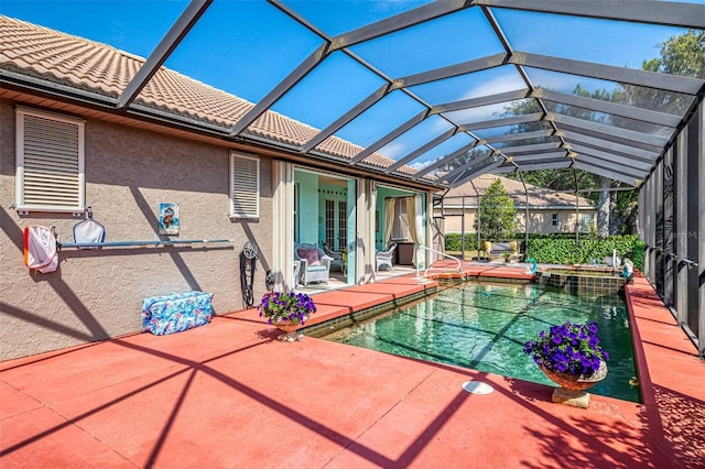 view of swimming pool featuring a patio, a lanai, and a pool with connected hot tub