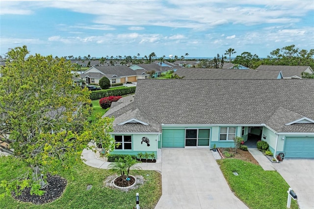 view of front of property featuring roof with shingles, a garage, driveway, and stucco siding