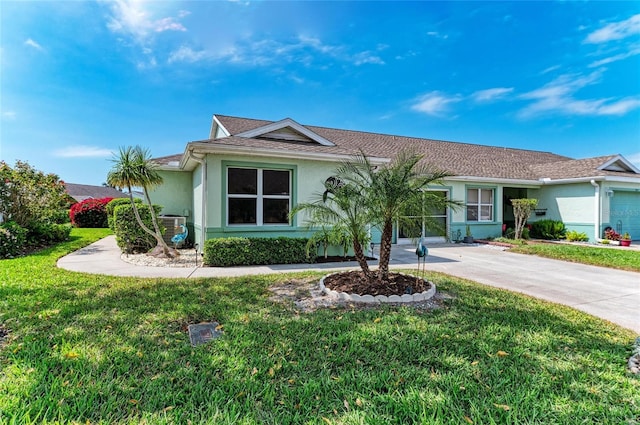 ranch-style house with a front lawn, concrete driveway, and stucco siding