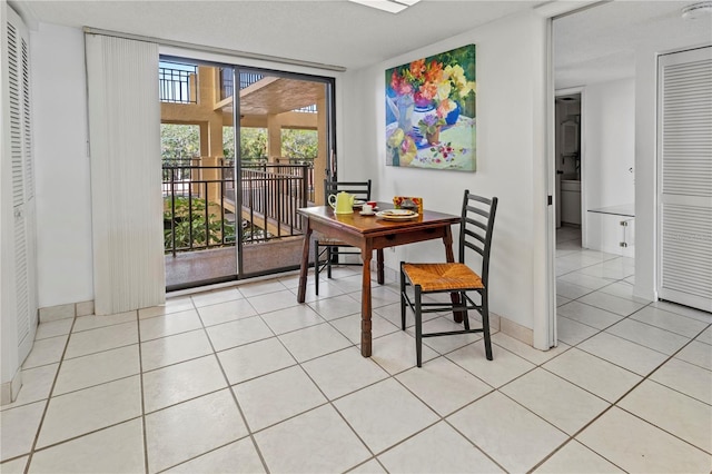 dining room featuring light tile patterned floors and a wall of windows