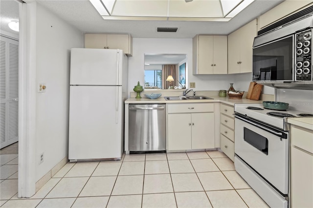 kitchen featuring light tile patterned floors, visible vents, a sink, stainless steel appliances, and light countertops