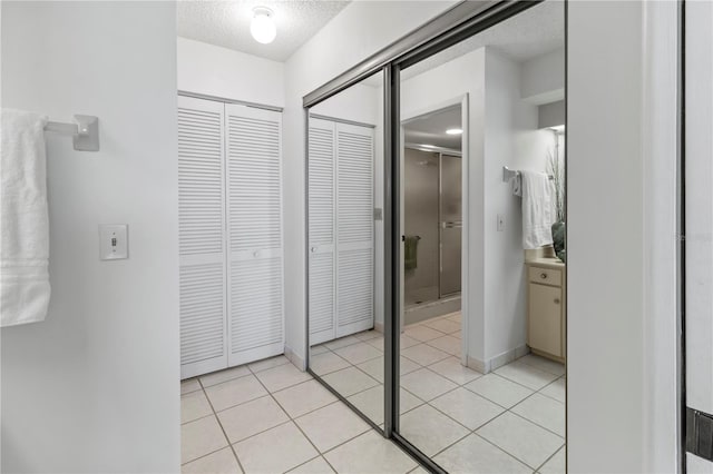 interior space featuring vanity, tile patterned floors, a closet, and a textured ceiling