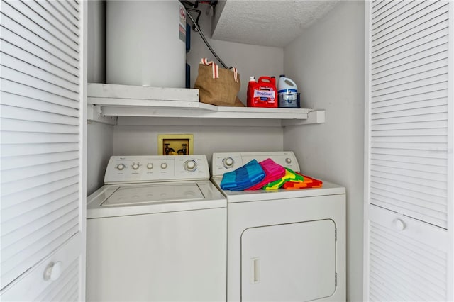 clothes washing area featuring a textured ceiling, laundry area, and washing machine and clothes dryer