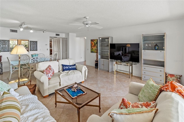 tiled living area with visible vents, a textured ceiling, and a ceiling fan