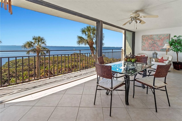 sunroom featuring a ceiling fan and a water view