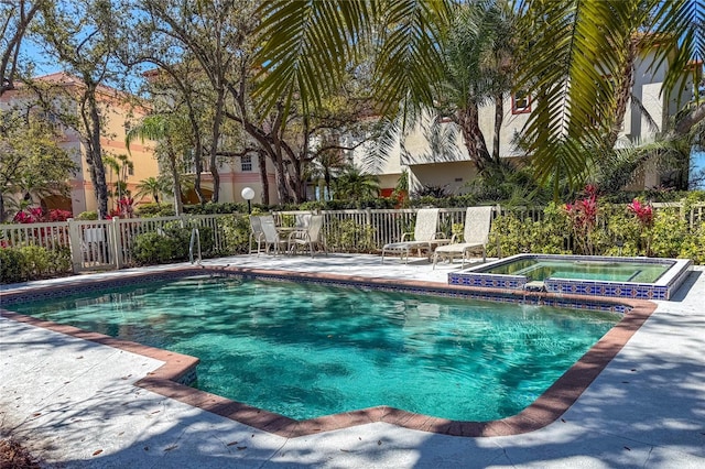 view of pool with a patio area, a fenced in pool, an in ground hot tub, and fence