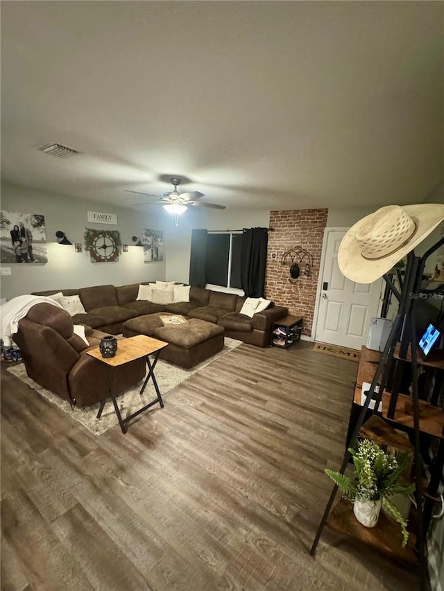 living area with wood finished floors, a ceiling fan, and visible vents