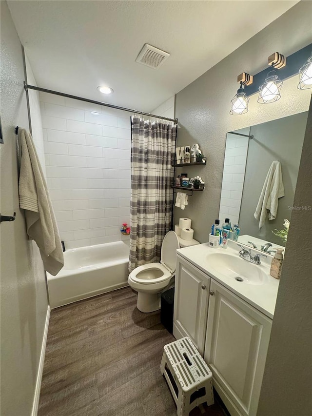 full bathroom featuring vanity, shower / bathtub combination with curtain, wood finished floors, visible vents, and toilet