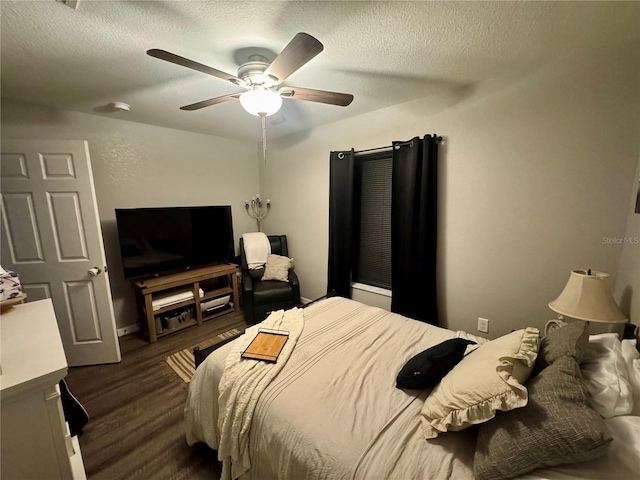 bedroom featuring a textured ceiling, dark wood-style floors, and a ceiling fan