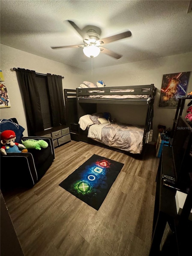 bedroom featuring ceiling fan, a textured ceiling, and wood finished floors