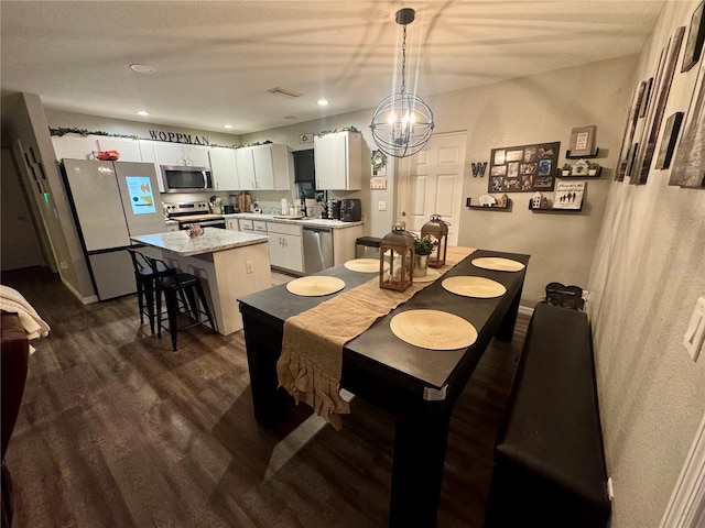 dining space featuring baseboards, visible vents, dark wood finished floors, an inviting chandelier, and recessed lighting