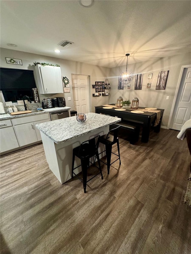 kitchen featuring visible vents, a sink, dark wood-type flooring, white cabinets, and dishwasher