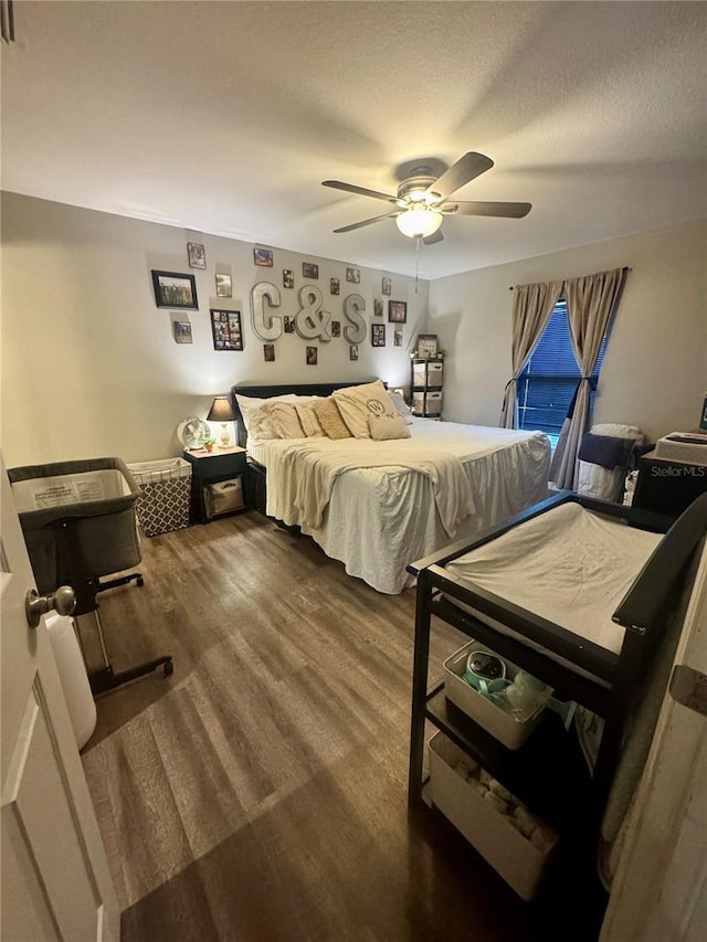 bedroom featuring a ceiling fan, wood finished floors, and a textured ceiling