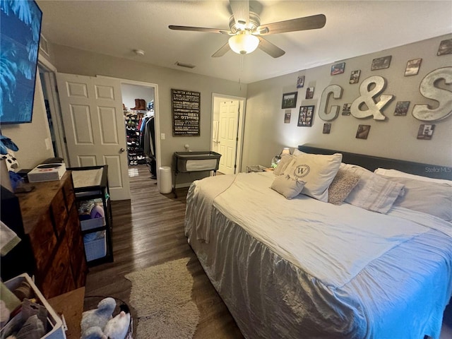 bedroom featuring visible vents, dark wood-style flooring, ceiling fan, a spacious closet, and a closet