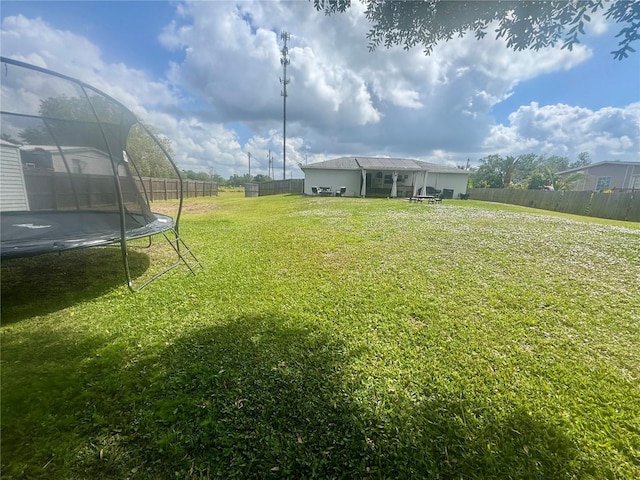 view of yard featuring a trampoline and a fenced backyard