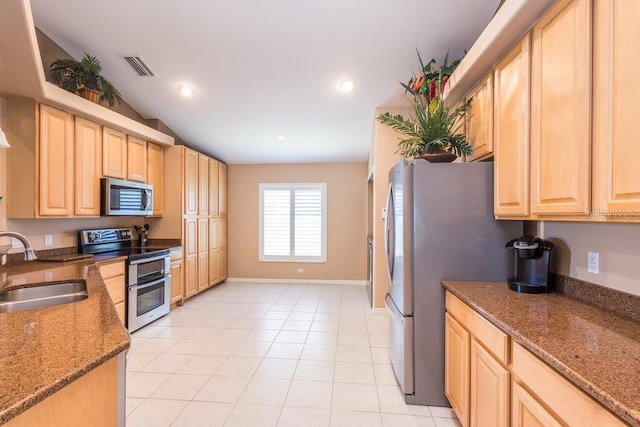 kitchen featuring light brown cabinetry, visible vents, appliances with stainless steel finishes, and a sink