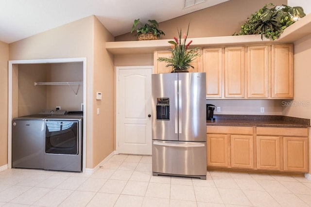 kitchen with washer and dryer, lofted ceiling, stainless steel fridge, and light brown cabinetry