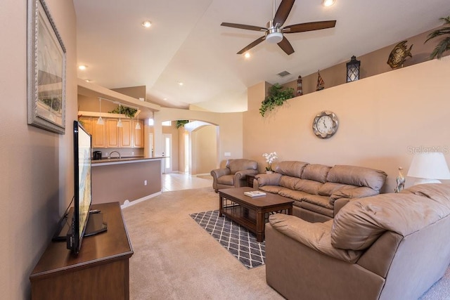 living room featuring visible vents, light colored carpet, arched walkways, high vaulted ceiling, and a ceiling fan