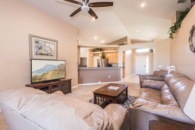 living room with light carpet, lofted ceiling, a ceiling fan, arched walkways, and baseboards