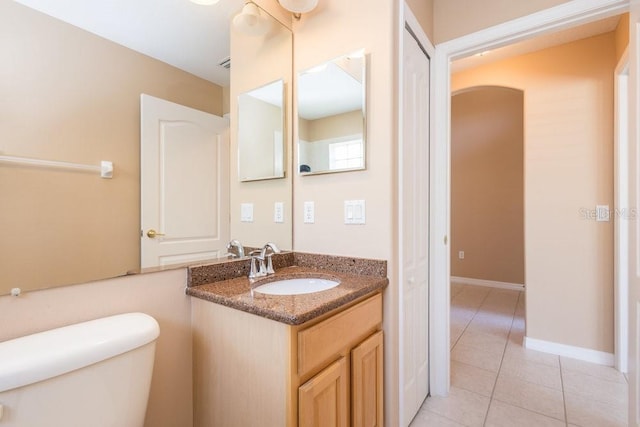 bathroom with tile patterned floors, baseboards, toilet, and vanity