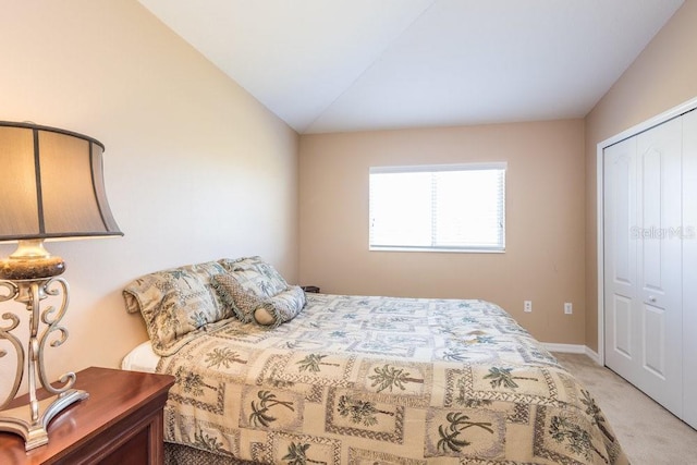 bedroom with a closet, baseboards, lofted ceiling, and carpet floors