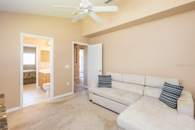 living area featuring tile patterned flooring, ceiling fan, baseboards, carpet, and vaulted ceiling