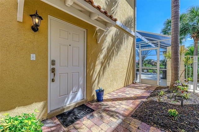 doorway to property featuring stucco siding and a tiled roof