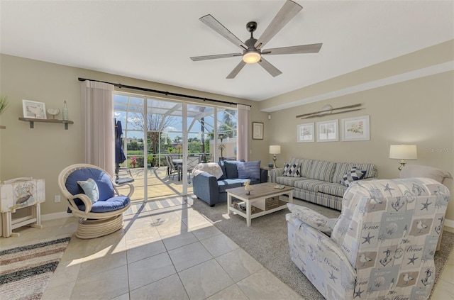 living area with light tile patterned floors, a ceiling fan, baseboards, and a sunroom