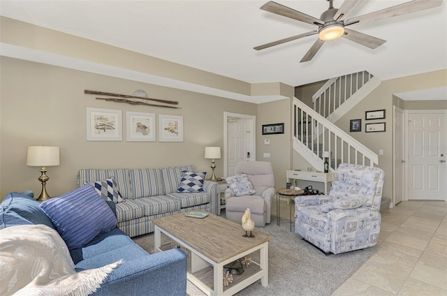 living area with stairway and a ceiling fan