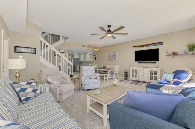 living room with visible vents, stairs, ceiling fan, and carpet floors