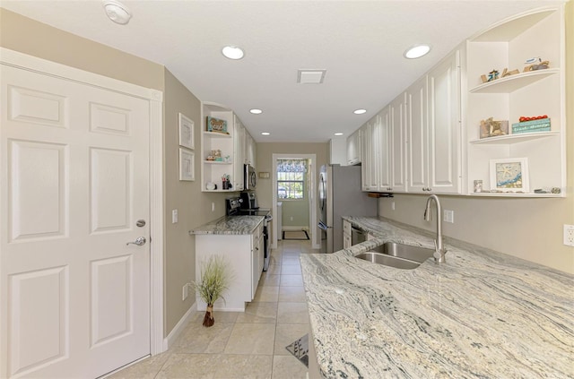 kitchen with visible vents, open shelves, a sink, appliances with stainless steel finishes, and white cabinets