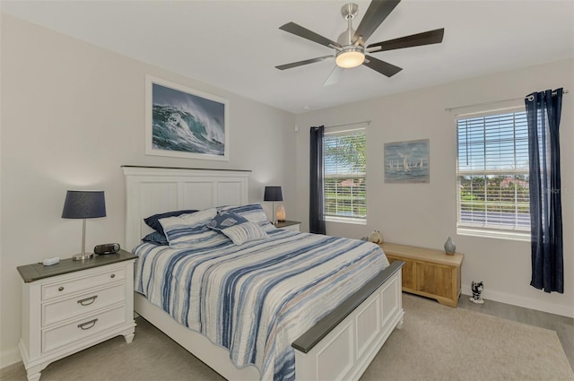 bedroom with baseboards, multiple windows, and ceiling fan