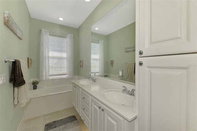 full bathroom featuring double vanity, a bath, tile patterned floors, and a sink