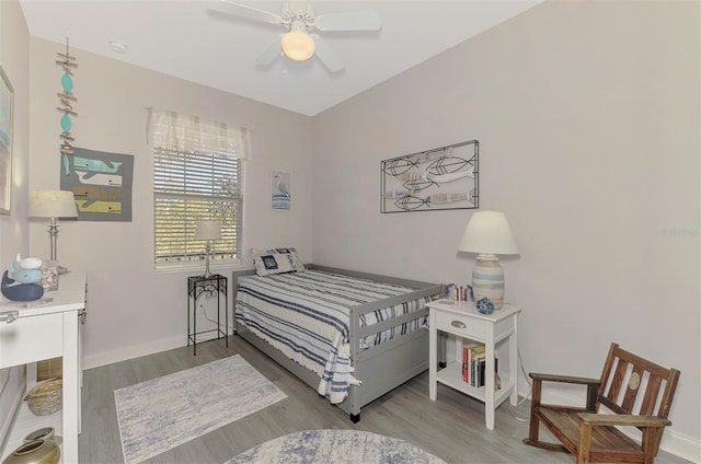 bedroom with a ceiling fan, baseboards, and wood finished floors