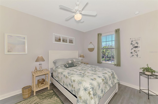 bedroom with baseboards, wood finished floors, and a ceiling fan