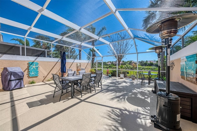 view of patio / terrace featuring glass enclosure, area for grilling, and outdoor dining space