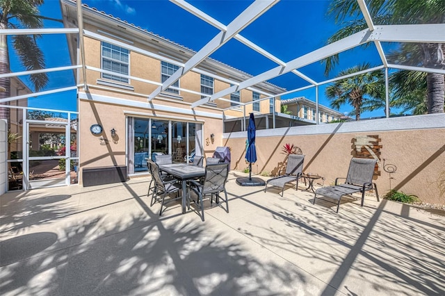 view of patio featuring glass enclosure