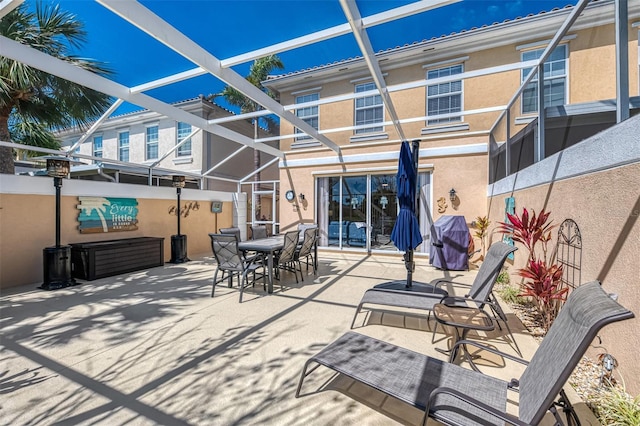 view of patio featuring a lanai, area for grilling, and outdoor dining area