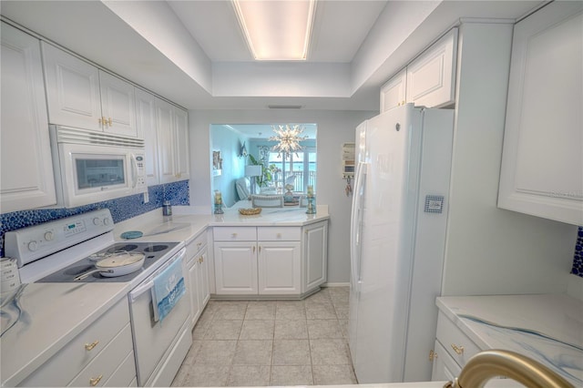 kitchen featuring visible vents, a tray ceiling, light tile patterned floors, white cabinets, and white appliances