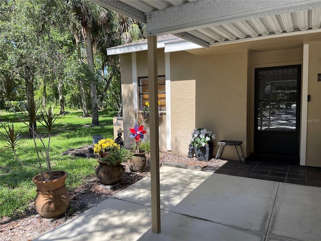 5013 Village Gardens Dr Unit 34, Sarasota, FL 34234 - entrance to property with stucco siding, a patio, and a lawn