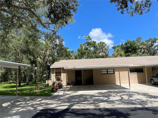 5013 Village Gardens Dr Unit 34, Sarasota, FL 34234 - garage featuring an attached carport and concrete driveway