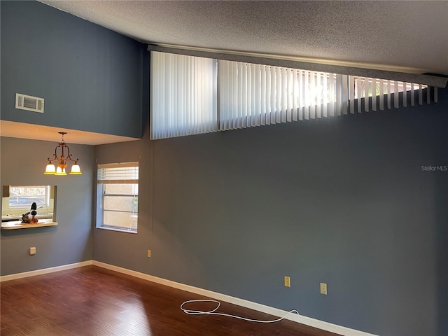 5013 Village Gardens Dr Unit 34, Sarasota, FL 34234 - empty room with a chandelier, a textured ceiling, and wood finished floors