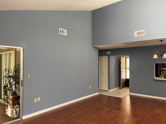 5013 Village Gardens Dr Unit 34, Sarasota, FL 34234 - empty room with a high ceiling, wood finished floors, and a chandelier