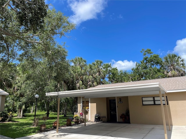 5013 Village Gardens Dr Unit 34, Sarasota, FL 34234 - view of front of home with stucco siding, a front lawn, and roof with shingles