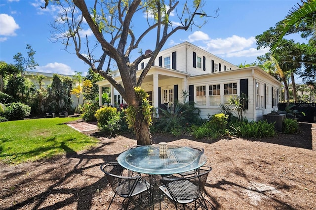 rear view of property with a yard and central AC