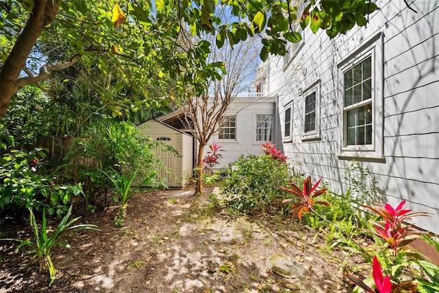 view of yard with a storage shed, an outdoor structure, and fence