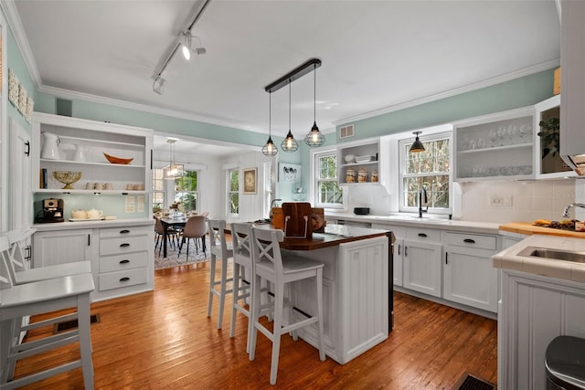 kitchen with visible vents, crown molding, light wood-type flooring, white cabinetry, and open shelves