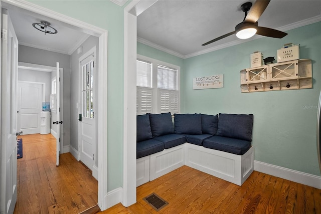 sitting room with visible vents, crown molding, baseboards, wood finished floors, and a ceiling fan