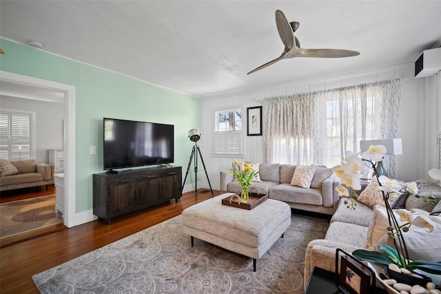 living room featuring baseboards, ceiling fan, and wood finished floors